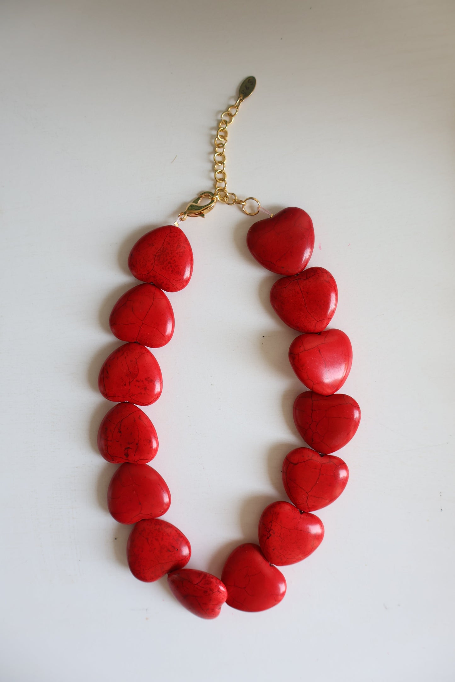 Red heart-shaped necklace on a white background