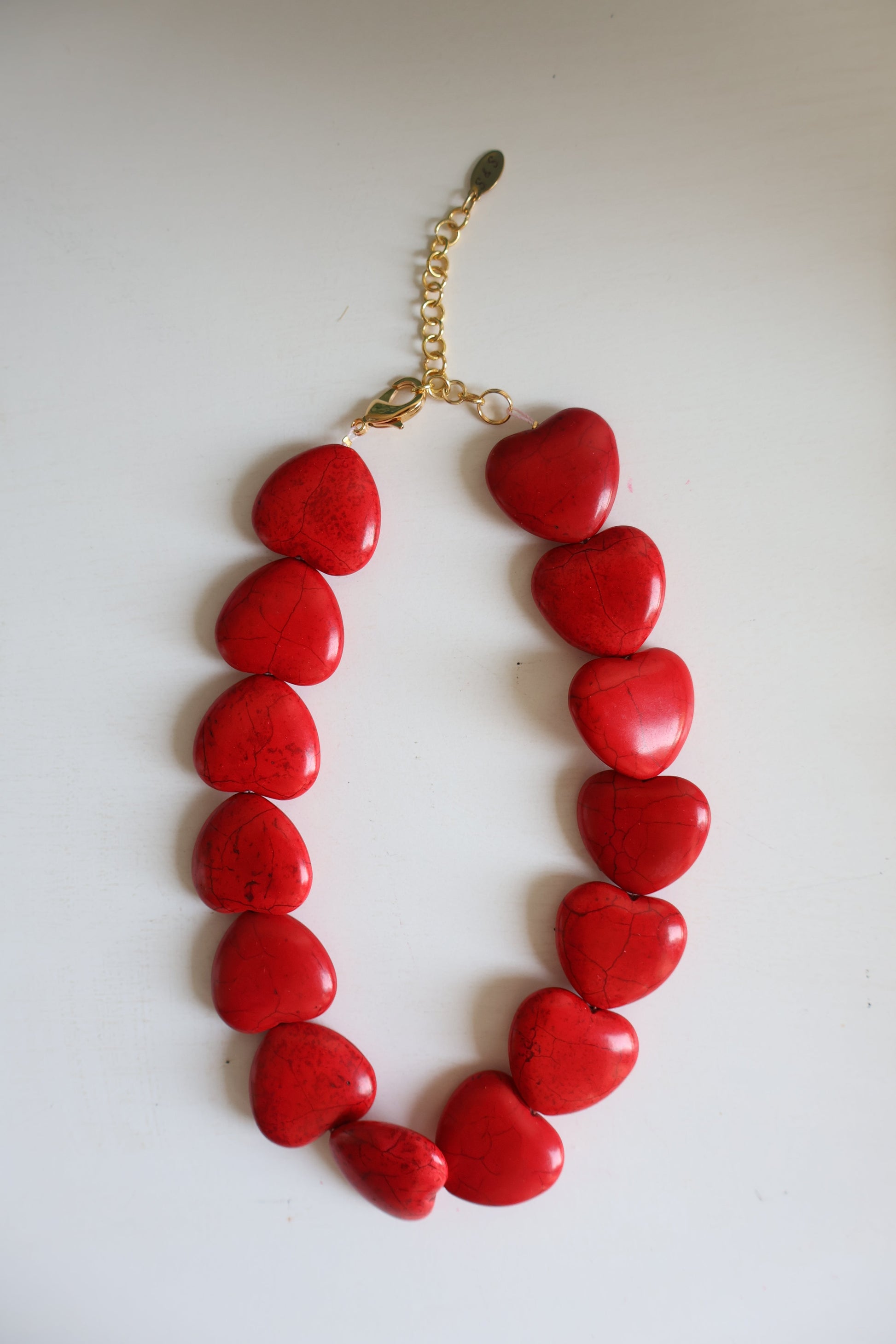 Red heart-shaped necklace on a white background